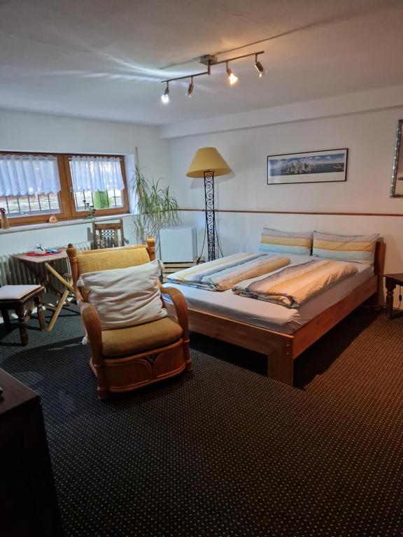a bedroom with a large bed and a chair at Großes gemütliches Zimmer mit eigener Dusche in Rheinstetten