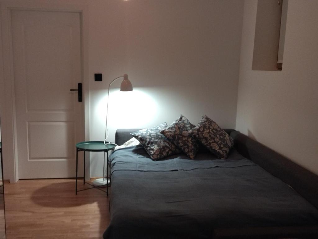 a bedroom with a bed with a lamp and a table at Cosy Sacz in Nowy Sącz