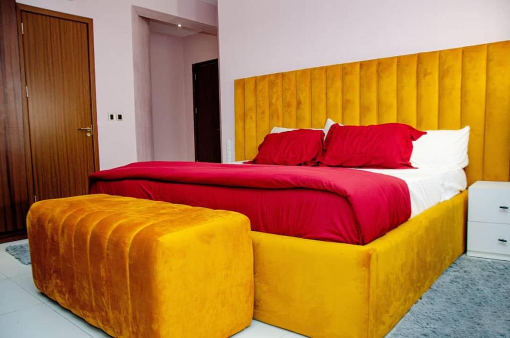 a bedroom with a large bed with red pillows at EXCLUSIVE ANSO Homes GRA Ikeja 1 bed room in Ikeja