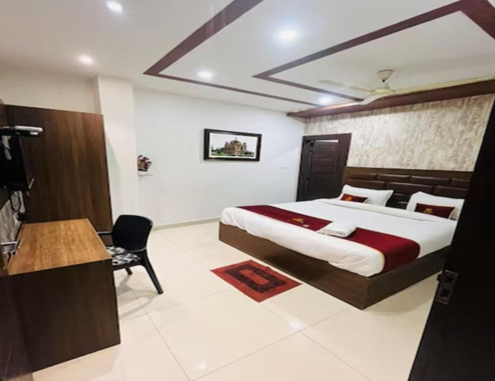 a bedroom with a bed and a desk in a room at GOEL INN in Allahābād