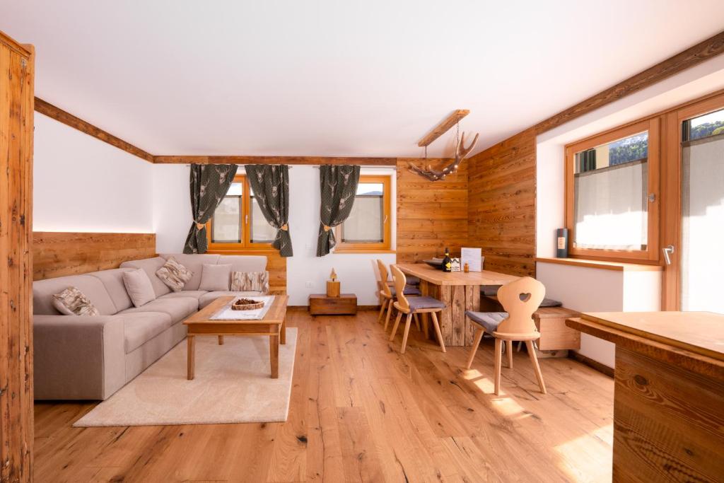 a living room with a couch and a table at Arga' New Alpine Design Apartment Central & Scenic Views in San Vito di Cadore