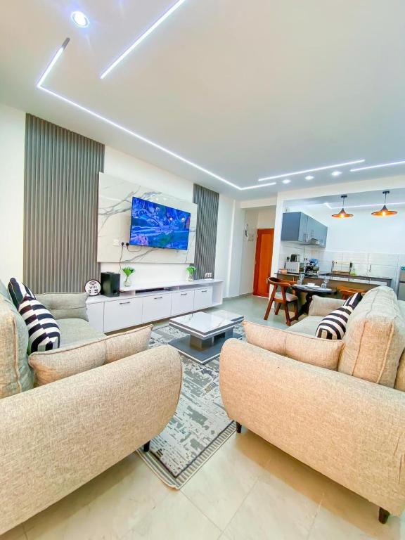 a living room with two couches and a flat screen tv at Nitro Homes Nyali-Coral Sands in Mombasa