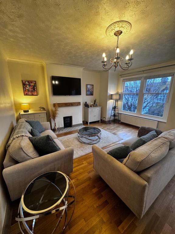 a living room with two couches and a tv at 2 bed apartment close to beach in Herne Bay