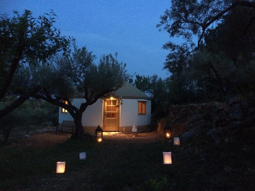 una pequeña cabaña blanca con velas delante de ella por la noche en Yurta Mongola Delta del Ebro, en Camarles