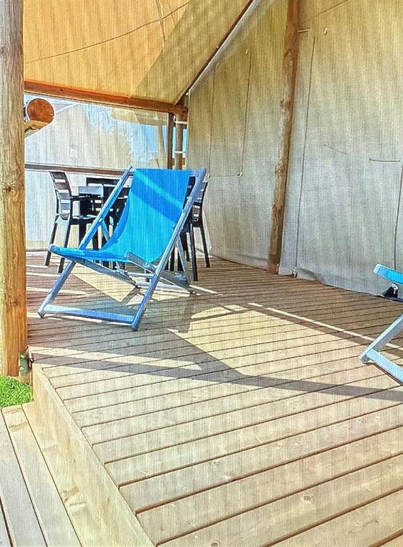 a pair of blue lounge chairs on a porch at glamping eco lodges in Moncarapacho