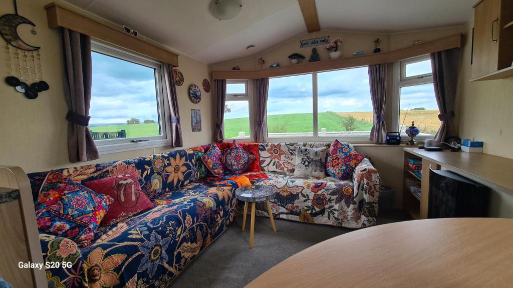 a living room with a couch and two windows at Meadows nook in Clitheroe