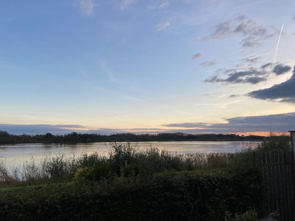 a view of a body of water at sunset at Huisje Scheldevallei in Temse