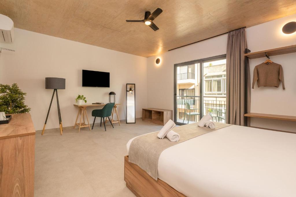 a bedroom with a large bed and a tv at 224 Boutique Hostel in Sliema