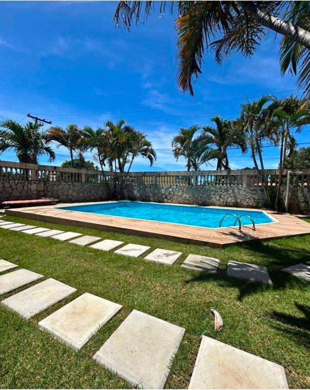 a swimming pool in a yard with palm trees at Praia do fort in Camacari
