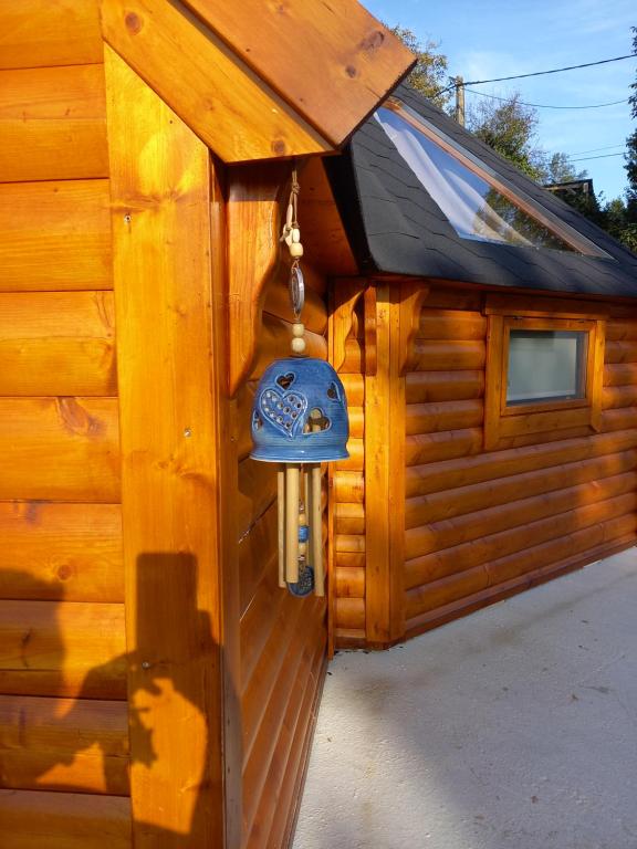 a wooden cabin with a blue bell on the side of it at Lodge Mon Petit Lapin in Montgon