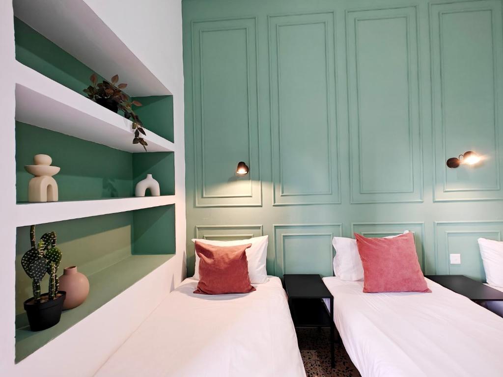 two beds in a room with green walls at Cosy room 9 in Tal-Pietà