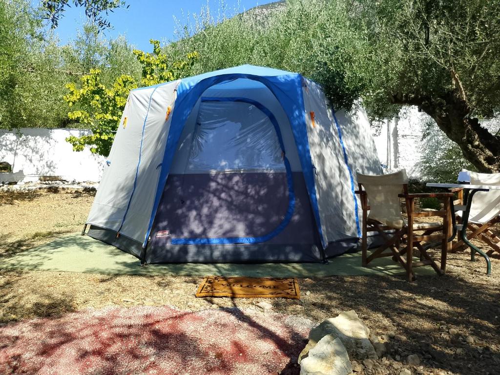 a blue and white tent with a table and a chair at Barreira beachfront Tents 9 in Verga Kalamata