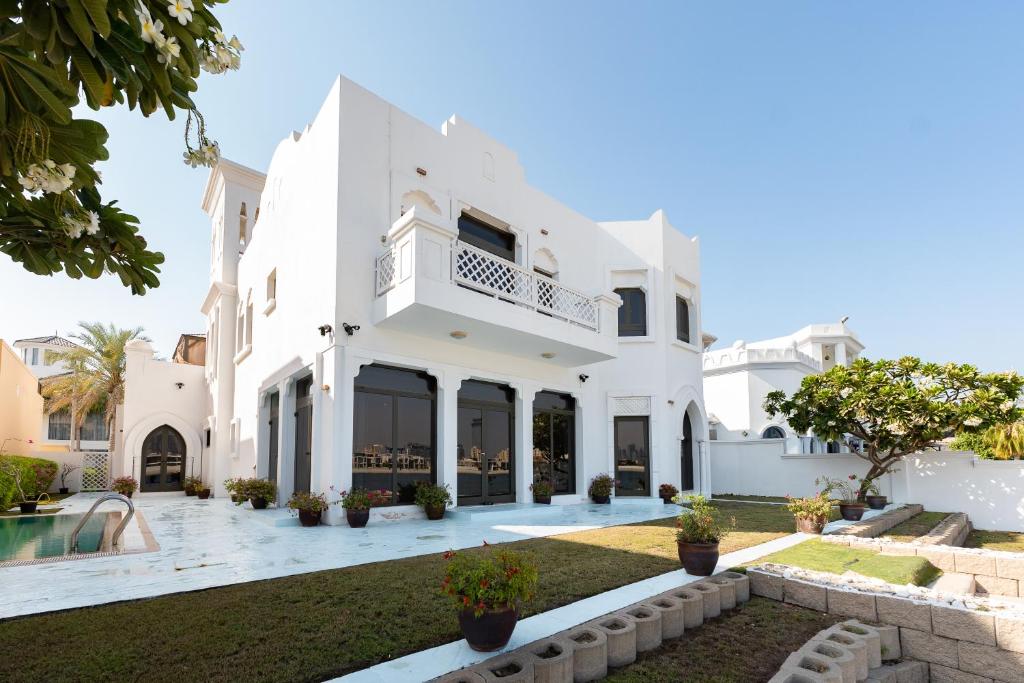 a white villa with a swimming pool at Palm Jumeirah - Property Advisers in Dubai