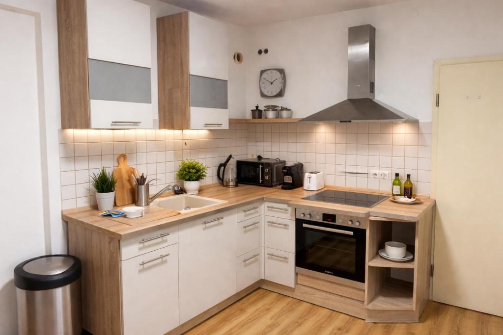 a kitchen with white cabinets and a sink at Platzreiches Apartment an der Mosel in Koblenz-Güls in Koblenz