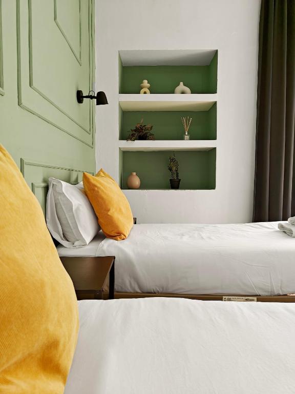 two beds in a room with green shelves at Cosy Room 8 in Tal-Pietà