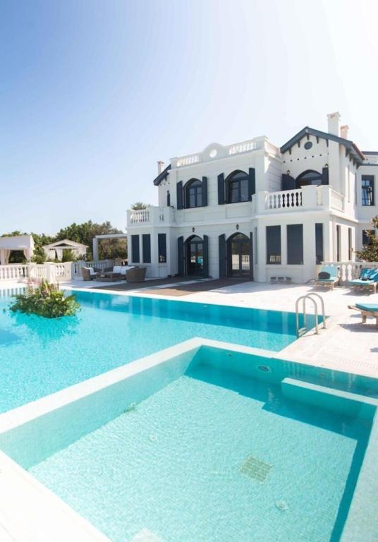 a large swimming pool in front of a house at Mikamas Villas in Pyrgi Thermis