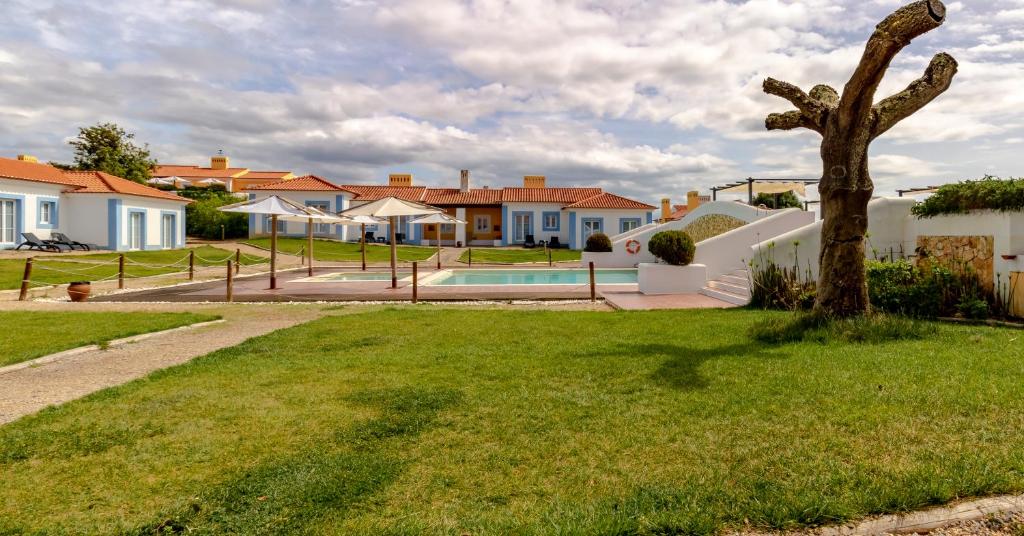 a house with a palm tree in a yard at Monte do Giestal - Casas de Campo & Spa in Abela