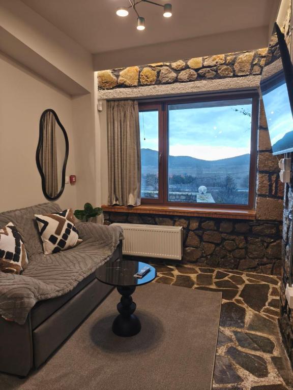 a living room with a couch and a large window at Φεγγαρόπετρα-Ημισέληνος in Kalívia