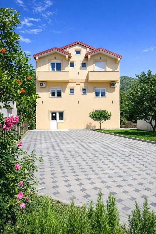 a large yellow house with a large driveway at Tomm in Trebinje