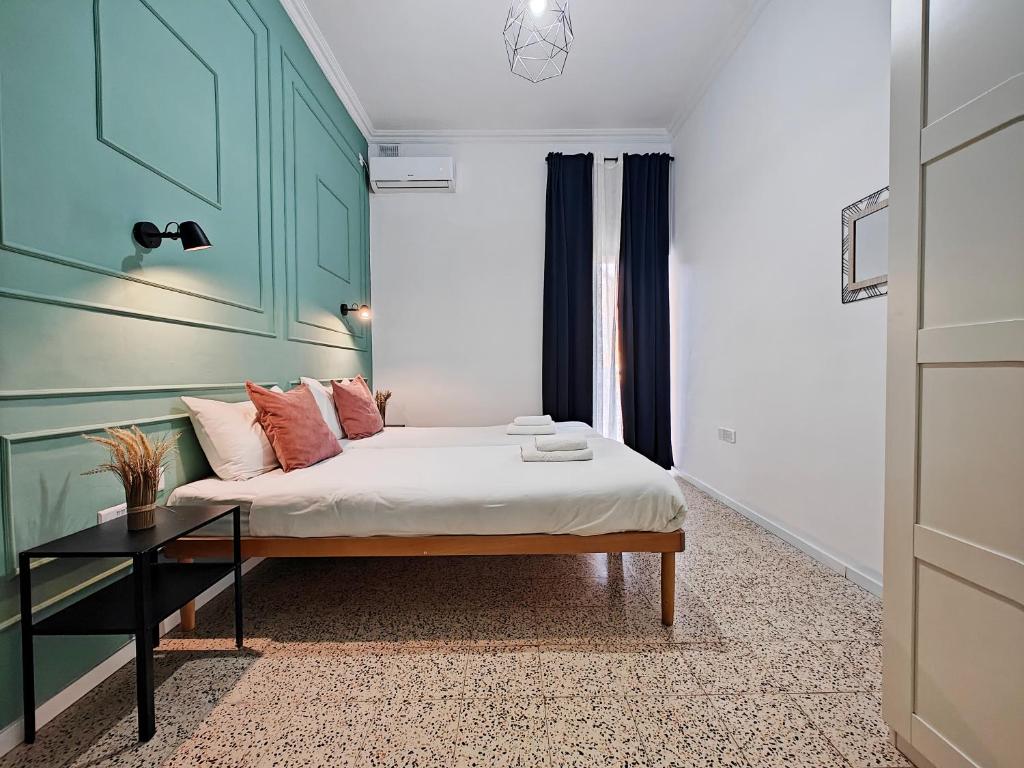 a bedroom with a bed with a green headboard at Cosy room 6 in Tal-Pietà
