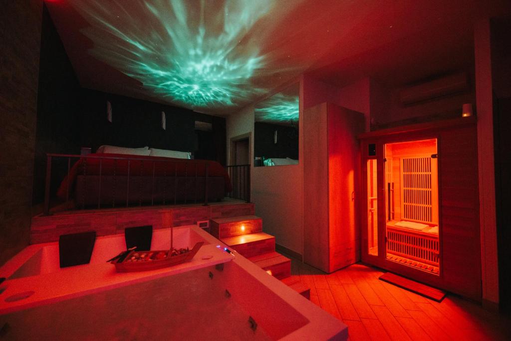 a room with a tub and a bed with red lights at Sweetlove Spa in Terracina