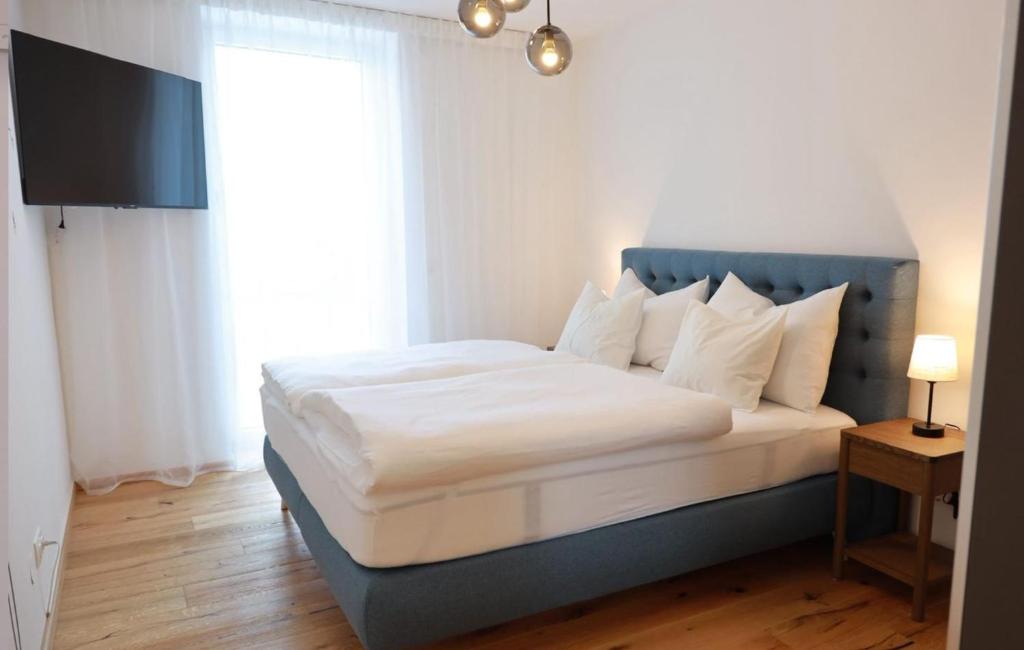a bedroom with a large bed with a blue headboard at Apartments Kellergasse in Purbach am Neusiedlersee