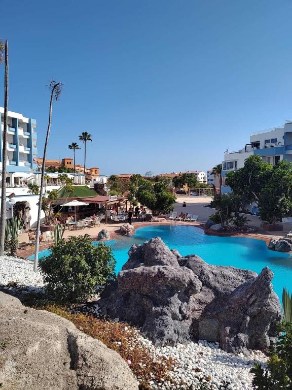 a swimming pool with blue water in a resort at Green Park ApartHotel Tenerife in San Miguel de Abona