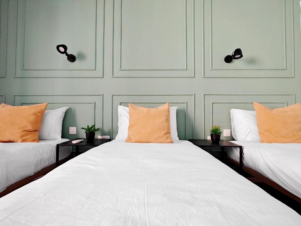 two beds with orange pillows in a room at Cosy room 5 in Tal-Pietà