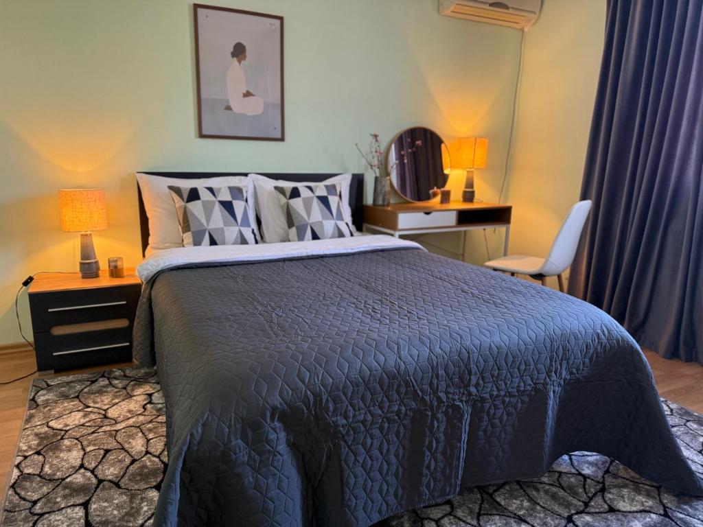 a bedroom with a bed with a blue comforter at Odessa Guest House-City Center in Chişinău