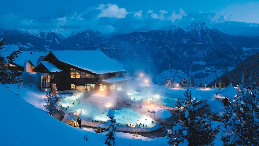 a resort covered in snow at night with lights at Centre Thermal 2 chambres studio EV110 in Ovronnaz