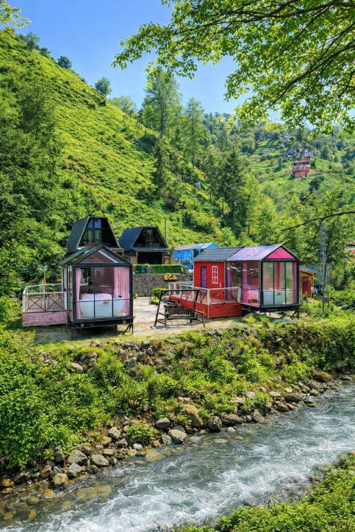 a group of tiny houses next to a river at Eça River Bungalov in Ayder Yaylasi