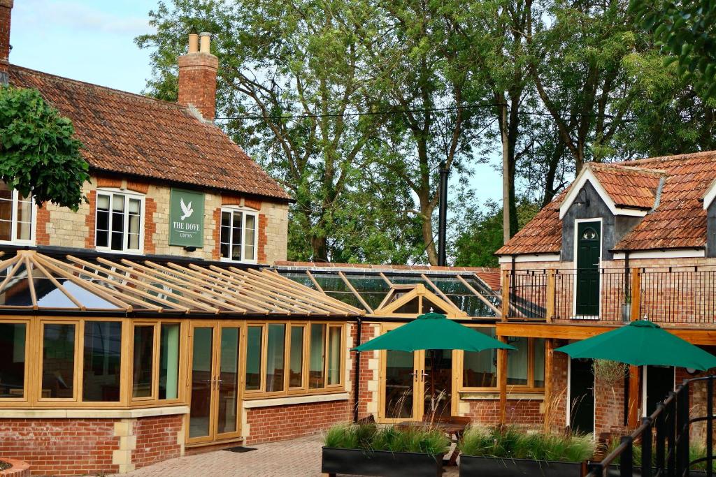 an external view of a building with green umbrellas at The Dove in Knook