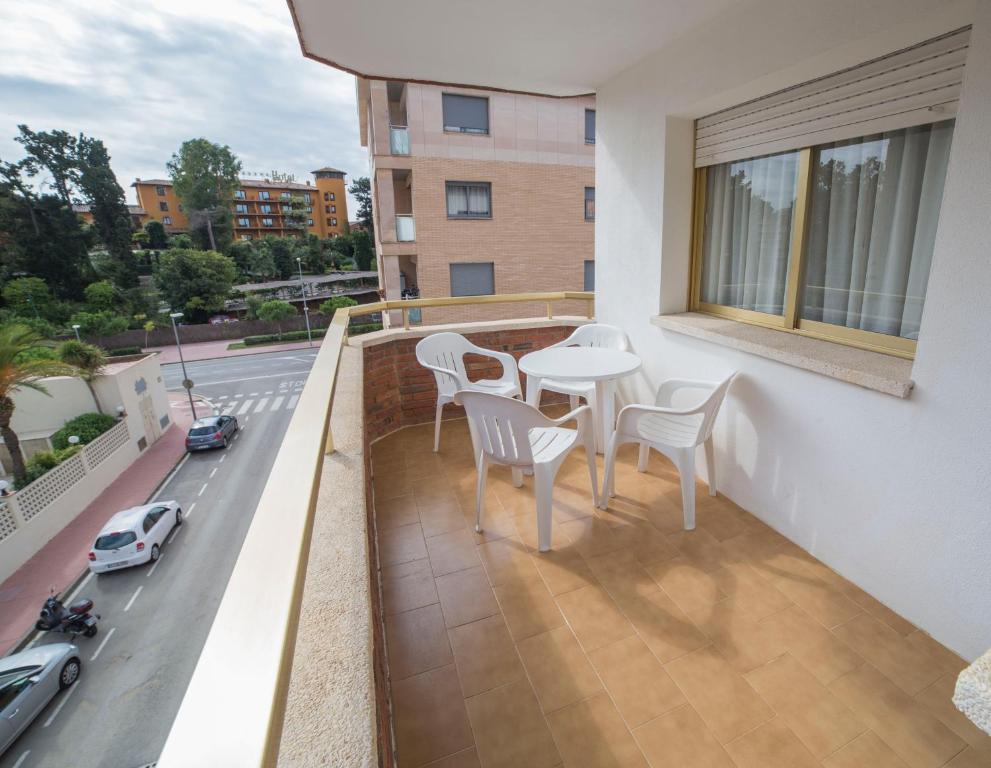 a balcony with a table and chairs and a street at Apartamentos Eldorado in Lloret de Mar