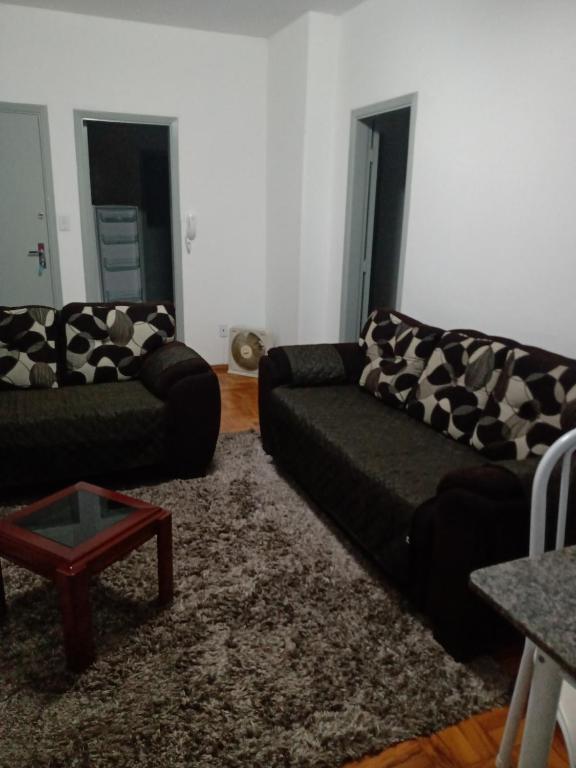 a living room with two couches and a table at Tranquility with convenience in Caxambú Tranquilo in Caxambu