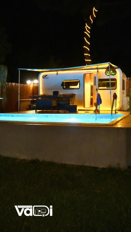 a rv with people standing outside of it at night at Vadi Karavan Otel in Buca