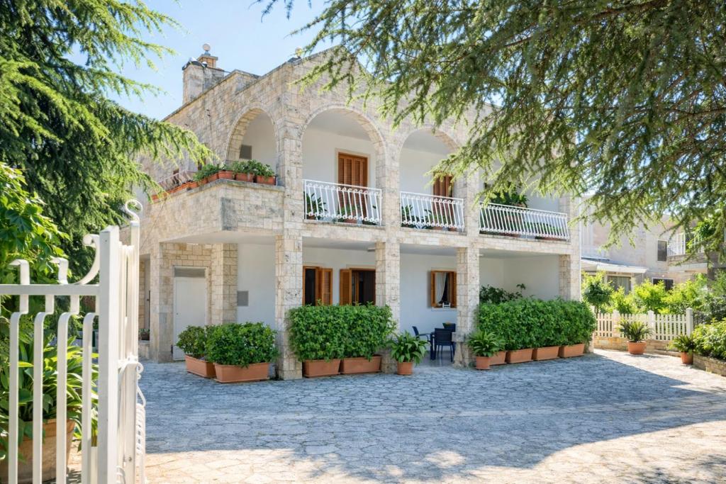 a house with a white fence and plants at B&B il Faso vicino Zoosafari di Fasano in Fasano