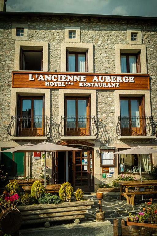 a building with a sign on the front of it at Hôtel Restaurant L'ancienne Auberge in Bolquere Pyrenees 2000
