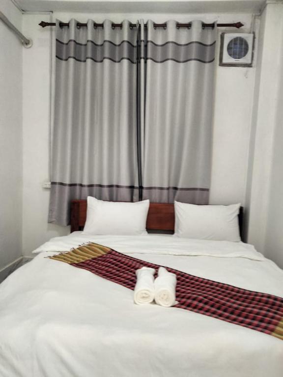 a bedroom with a bed with two towels on it at Khamfong Guesthouse in Pakbeng
