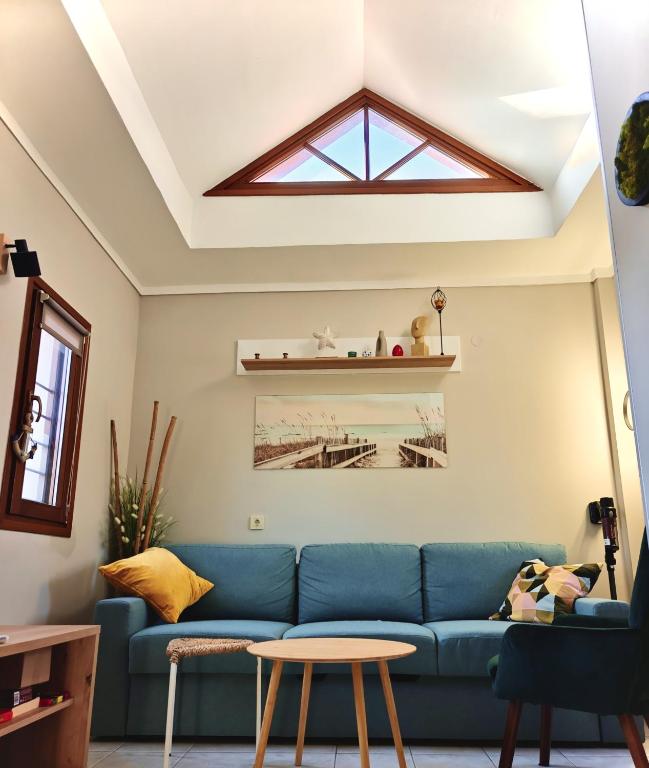 a living room with a blue couch and a skylight at Beach house IvMare in Ierissos