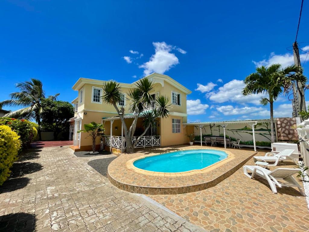 a house with a swimming pool and palm trees at Villa kartner in Albion