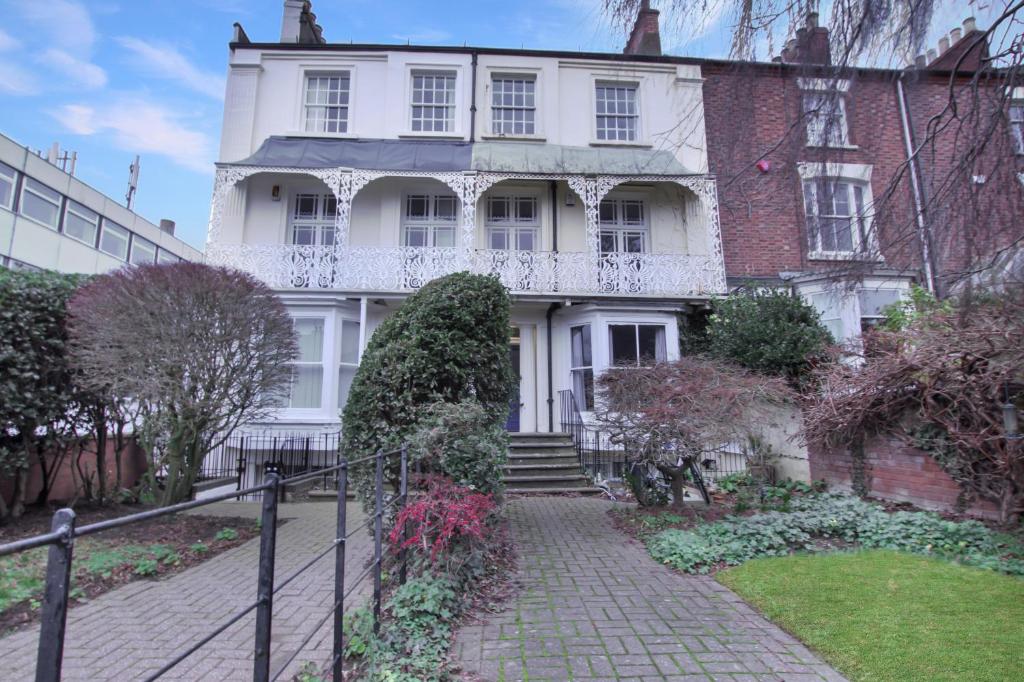 a large white house with a staircase in front of it at town house in Northampton