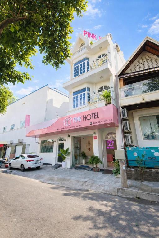 a building with a pink sign on top of it at PINK Hotel Cần Thơ in Can Tho