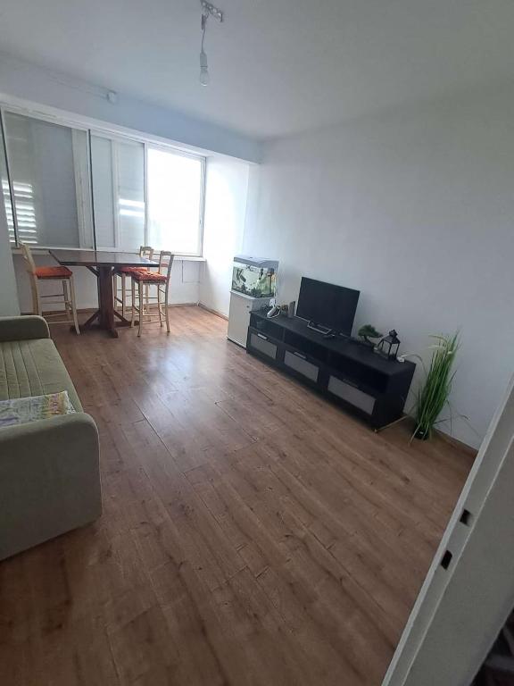 a living room with a piano and a dining table at Obtsinsky Beach in Haifa
