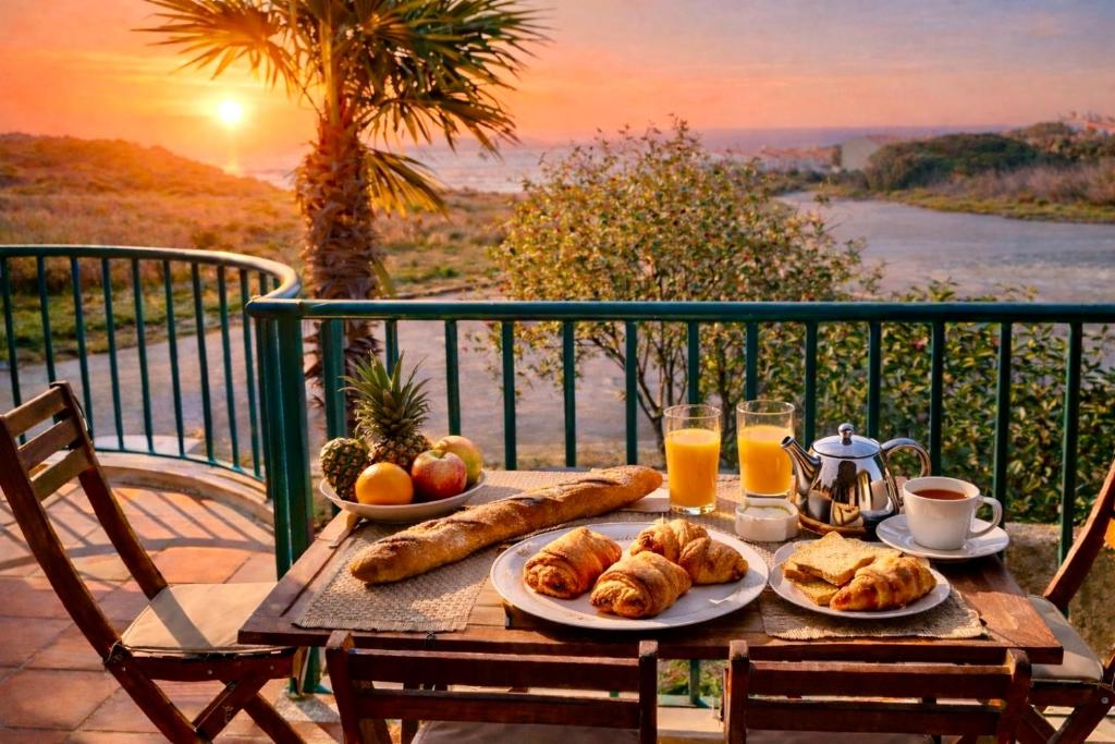 a table with a breakfast of croissants and orange juice at Casa Da luz 5 - sea view 2 bedrooms apt , beach & swimming-pool in Luz