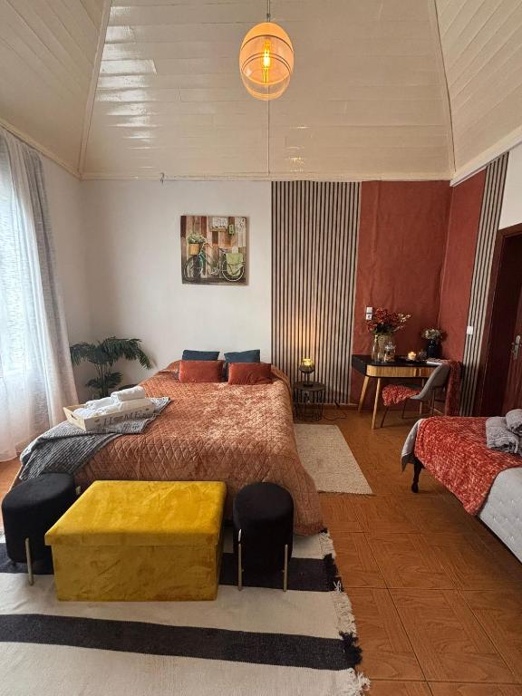 a bedroom with a large bed with a yellow table at Thomas Suite Calheta in Lombada dos Marinheiros