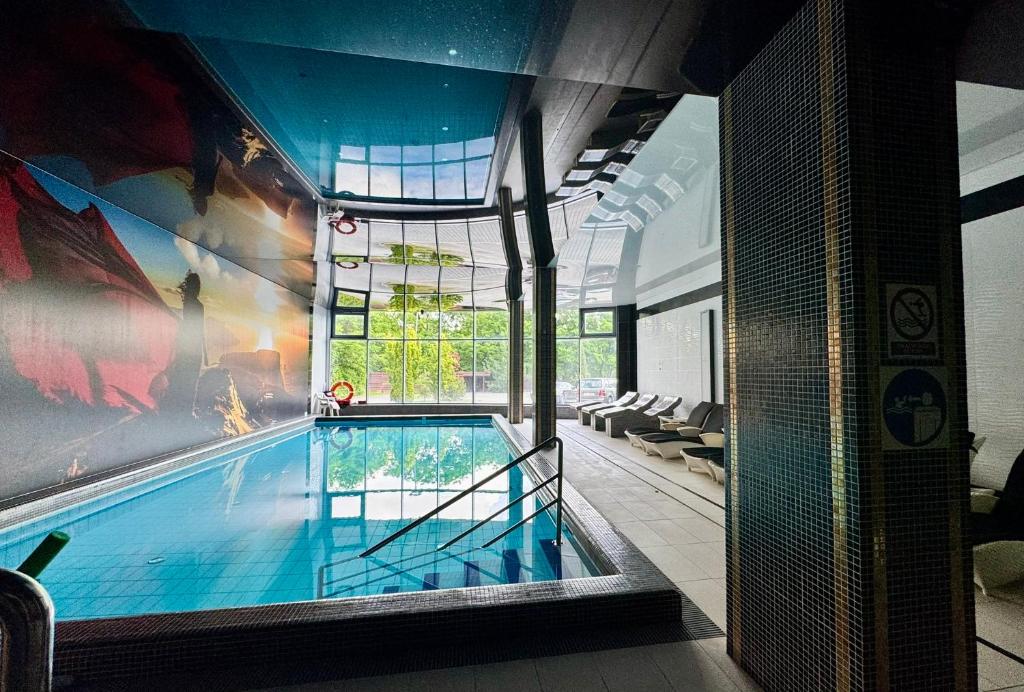 a large swimming pool in a building with a house at Hotel Business Faltom Gdynia in Gdynia