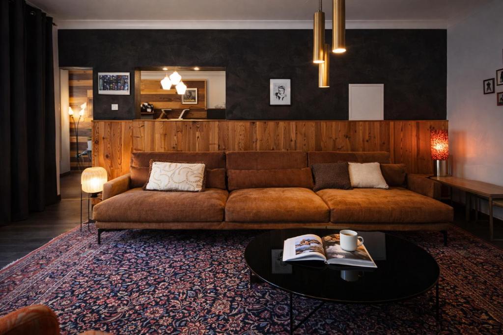 a living room with a couch and a table at Le Passage des Décorateurs T3 Spacieux et central in Mamers