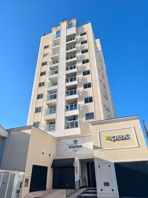 a tall building with a sign in front of it at bauer in Camboriú