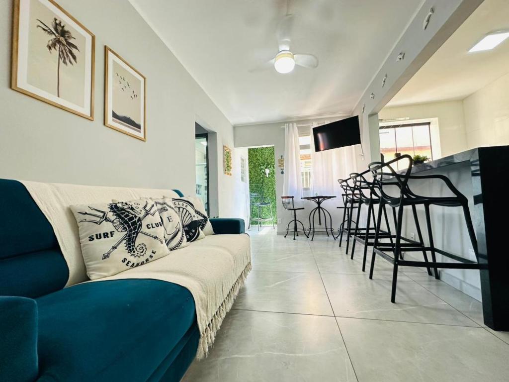 a living room with a blue couch and a table at Ap Aconchego 210 B in Ubatuba