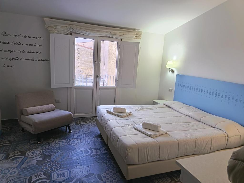 a bedroom with a large bed and a chair at Locanda B&B Dandana in Orgosolo